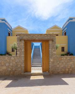 a stairway leading into a building with a wooden door at Asymi Residences in Symi