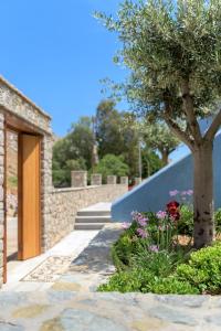 a garden with a tree and flowers next to a building at Asymi Residences in Symi