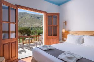 a bedroom with a bed and a balcony with a view at Asymi Residences in Symi