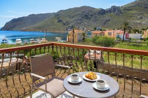 a table and chairs on a balcony with a view of the ocean at Asymi Residences in Symi