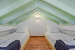 two beds in a room with green and white ceilings at Asymi Residences in Symi