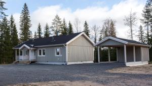 a house with a garage in the woods at Tiinan tupa B in Moksinkylä