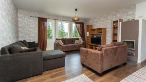 a living room with two couches and a tv at Tiinan tupa B in Moksinkylä