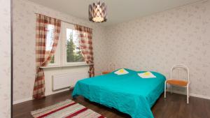 una camera da letto con un letto blu e una finestra di Tiinan tupa B a Moksinkylä