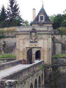 - un bâtiment en pierre avec un pont et un portail dans l'établissement Entre Estuaire et Citadelle, à Blaye