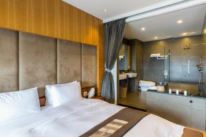 ein Schlafzimmer mit großem Bett und ein Badezimmer in der Unterkunft 輕塵別院Serenegray B&B in Wujie