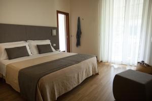una camera con un grande letto e una finestra di Hotel Miramare a Gabicce Mare