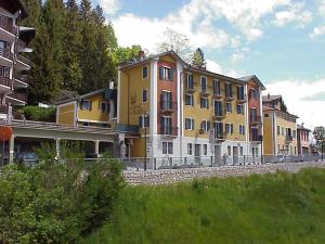 a row of buildings sitting next to a field at Hotel Al Pelmo Wellness in Pieve di Cadore
