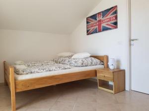 a wooden bed in a room with a picture on the wall at Apartment Patrizia in Zadar