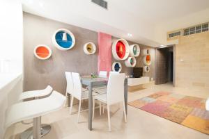 a dining room with a table and white chairs at Bianco Mare in Otranto