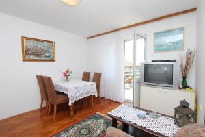 a living room with a table and a television at Apartments Monpeloso in Rovinj