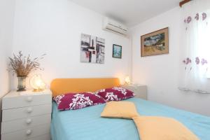 a bedroom with a blue bed and a white dresser at Apartments Monpeloso in Rovinj