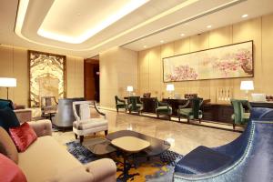 台北市にあるグランド メイフー タイペイのホテルのロビーには椅子とテーブル付きの待合室があります。
