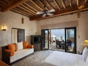 ディバにあるSix Senses Zighy Bayのリビングルーム(ソファ、テレビ、パティオ付)