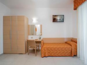 a bedroom with a bed and a desk with a table at Hotel Tibidabo in Bellaria-Igea Marina