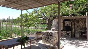 un tavolo da picnic sotto un padiglione con un albero di Casa Vacanze Reginotte a Balestrate