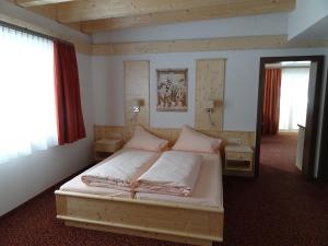 エールヴァルトにあるAppartements Loisachpromenadeのベッドルーム1室(白いシーツと鏡付きのベッド1台付)
