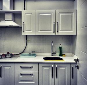 a kitchen with white cabinets and a sink at Tk Kurdal Suit Otel in Samsun