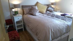 a bedroom with a white bed with pillows on it at Canterbury Cottage in Prestatyn