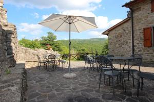 a group of tables and chairs with an umbrella at Agriturismo Badia Ficarolo in Palazzo del Pero