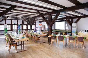 une salle à manger avec des tables et des chaises dans un bâtiment dans l'établissement Springbach-Mühle Belzig, à Bad Belzig