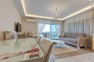 a living room with a table and a couch at Paris Residence Cesme in Çeşme