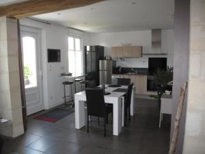 een keuken met een witte tafel en stoelen. bij La Maison Des Chiens Rouges in Berneuil-sur-Aisne