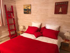 um quarto com uma cama com almofadas vermelhas e uma escada vermelha em Chez Phil et Dom em Biarritz