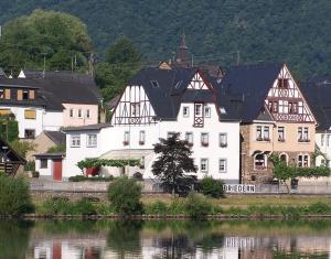 a large white building next to a body of water at Pension Mosellablick in Briedern