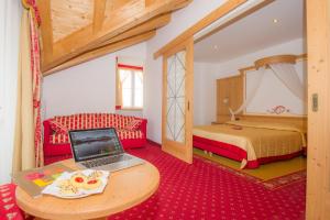 - une chambre avec un ordinateur portable sur une table et un lit dans l'établissement Sport Hotel Vittoria, à Passo del Tonale