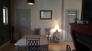 a dining room with a table and chairs and a fireplace at DEMEURE 300m DE LA PLAGE in Soulac-sur-Mer