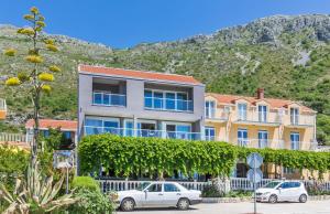 a large building with cars parked in front of it at Boutique Flamingo B&B in Mlini