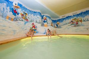 Eine Gruppe Mädchen, die im Schwimmbad sitzen in der Unterkunft Sport Hotel Vittoria in Passo del Tonale
