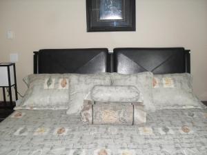 a bed with a black headboard and pillows at Mountain View Radium Condo - Copper Horn Village in Radium Hot Springs