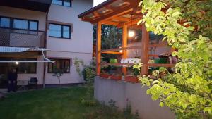 a house with a wooden pergola in a yard at Sarajevo gardens in Sarajevo