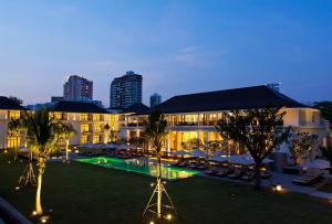 un hotel con piscina di fronte a un edificio di U Sathorn Bangkok a Bangkok