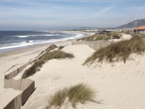 a sandy beach with a fence and the ocean at Millhousedune in Cepães