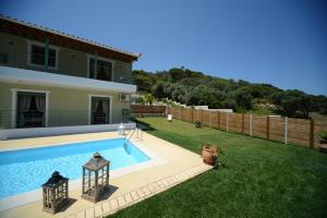 a backyard with a swimming pool and a house at Aselinos Suites in Koukounaries