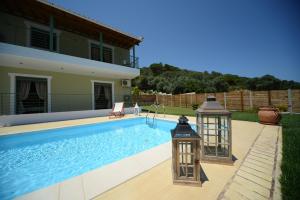 a swimming pool with two lights next to a house at Aselinos Suites in Koukounaries