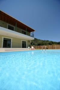 a large swimming pool in front of a house at Aselinos Suites in Koukounaries