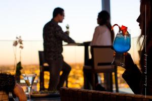 un hombre sentado en una mesa con una bebida azul en The View Rabat, en Rabat