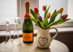 a table with two bottles of wine and a vase of flowers at Panorama in Tenby