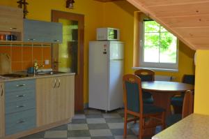 uma cozinha com um frigorífico branco e uma mesa em Chata Danuše em Ludvíkov