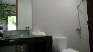 W łazience znajduje się umywalka, toaleta i lustro. w obiekcie Kubu Carik w mieście Legian