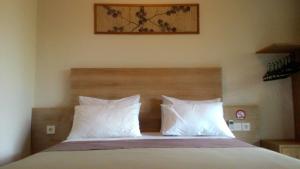 una camera da letto con un letto con cuscini bianchi di Kubu Carik a Legian