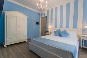a bedroom with a white bed and blue walls at Les Suites Magnolia in Olbia