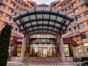 a large building with a sign in front of it at Flora Hotel - Apartments in Borovets