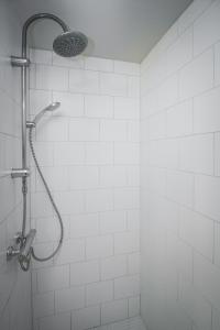 e bagno piastrellato bianco con doccia con soffione. di Apartment 19 a Selfoss