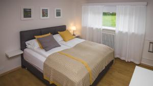 Un dormitorio con una cama con almohadas amarillas y una ventana en Apartment 19 en Selfoss