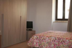ビシェーリエにあるLa Dimora del Borgoのベッドルーム(ベッド1台、ドレッサー内のテレビ付)